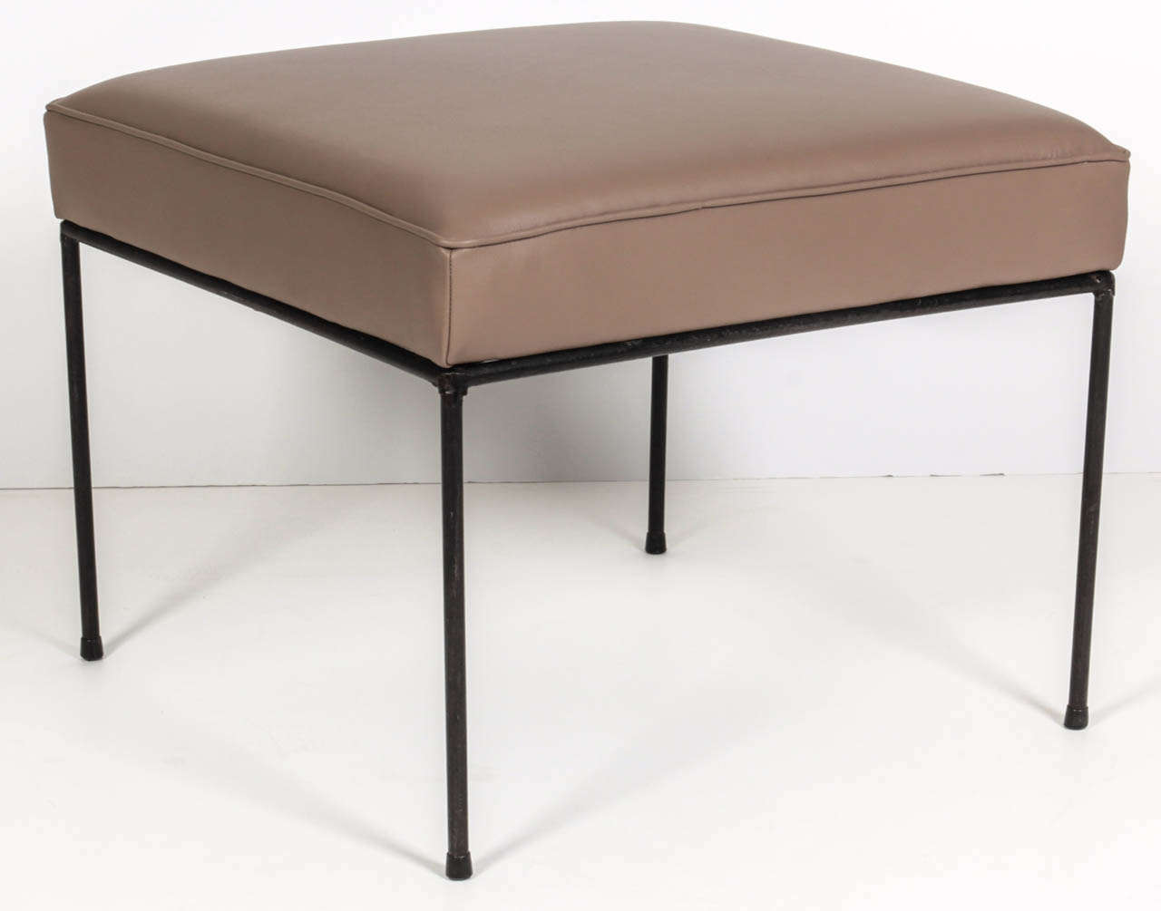 A pair of Mid Century classic blackened iron stools with new grey/brown leather upholstery. Designed by Paul McCobb.