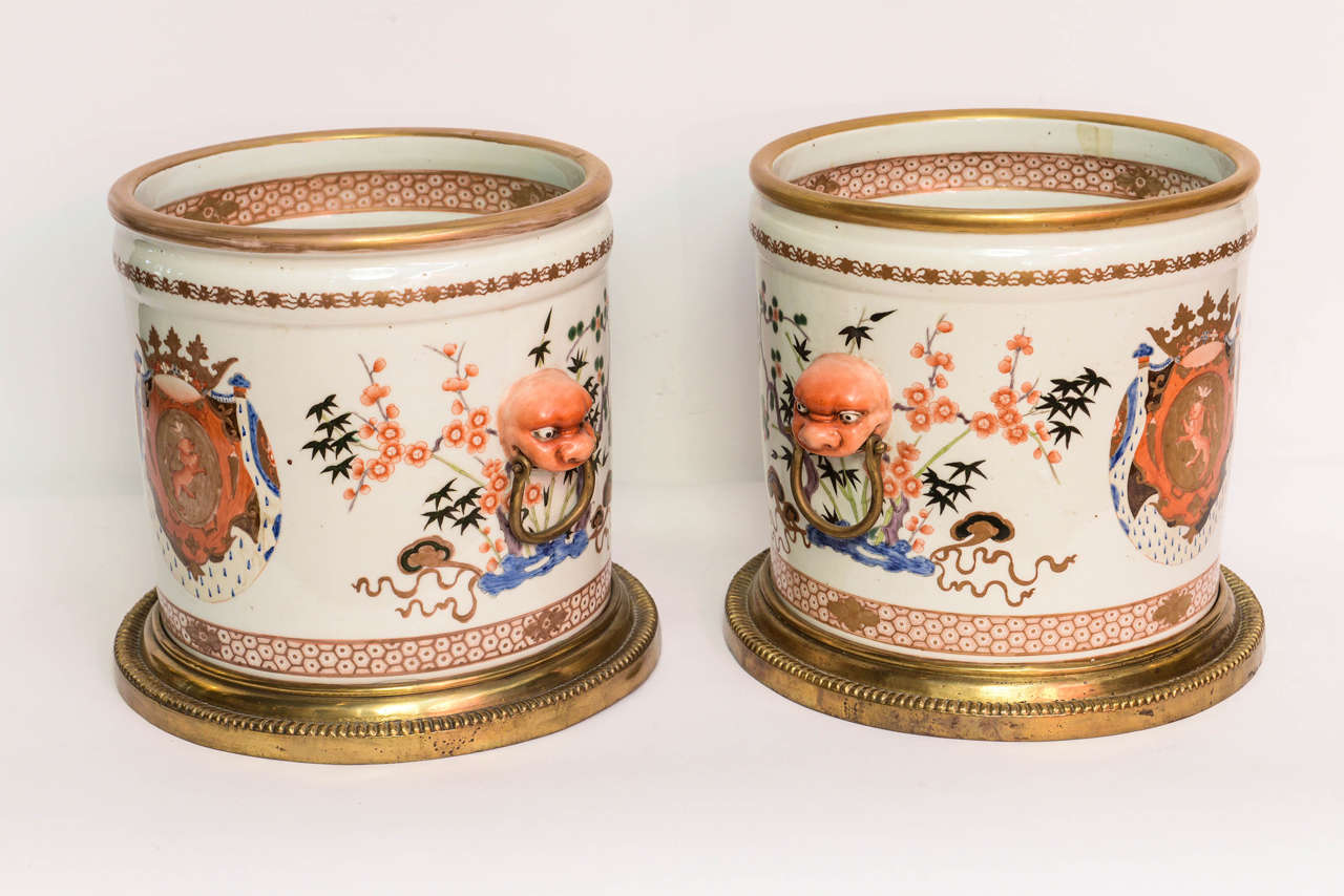 Striking pair of large-scale armorial cachepots in the Chinese export style on bronze bases.