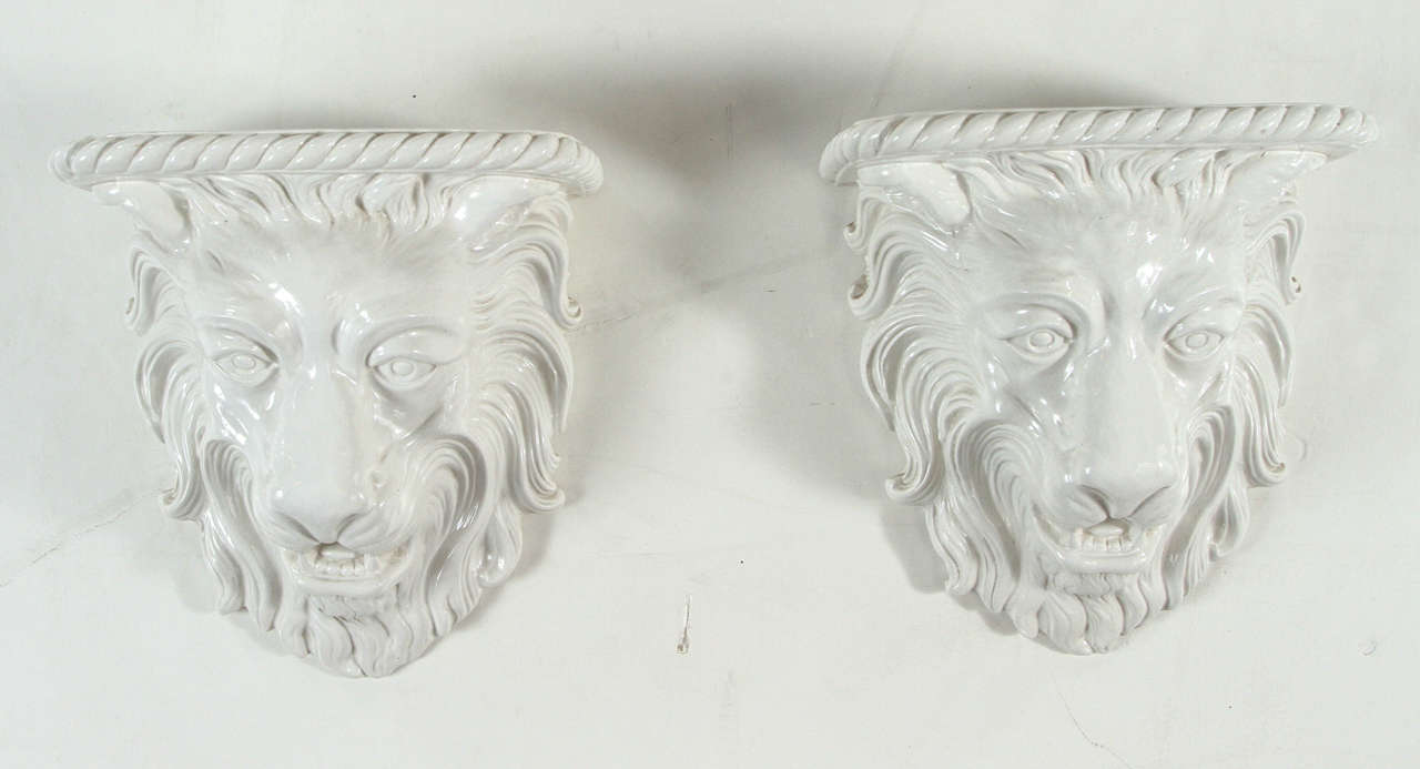 Two Italian porcelain lion head wall corbels with wall hangers built into each piece.