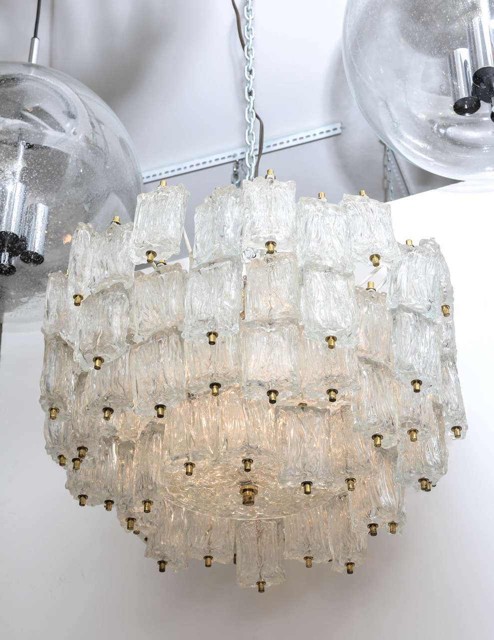 Murano glass multi-tiered chandeliers by Barovier e Toso with rectangular clear textured pendants supported by a white iron frame with brass hardware.