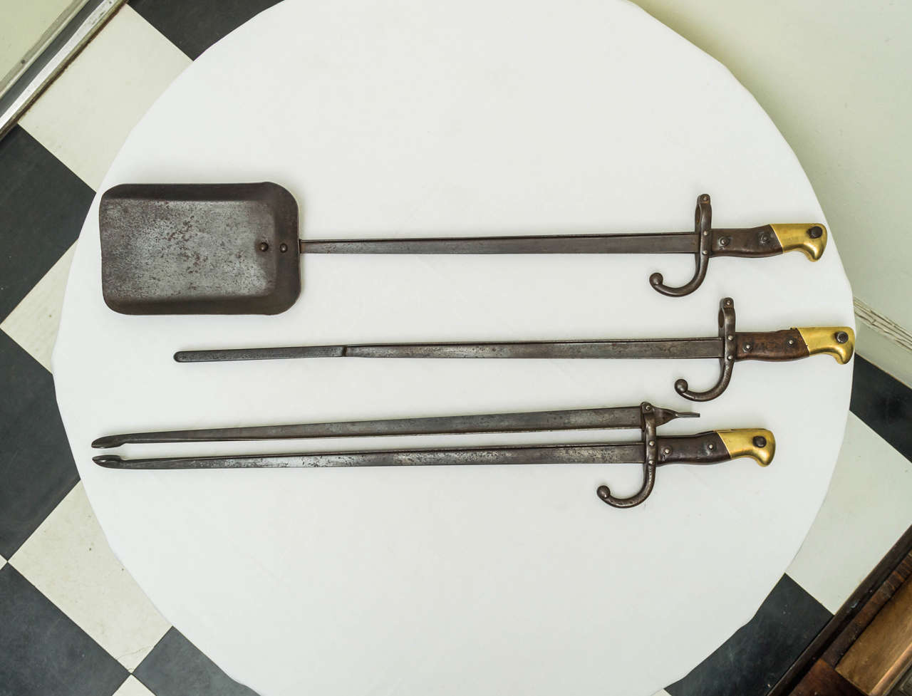 Set of three French bayonet forged fire tools.  Each blade with Armory touch marks on the upper ends and guards. The top ridges of the blade marked: MRe dei Chaps Juin, 1875,1882. Uniquely hand forged as a very stable set of fire tools. Excellent
