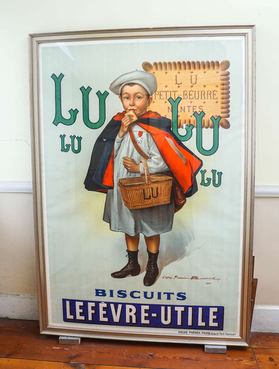 Very large LU biscuit (Lefevre-Utile) poster, circa 1897. After Firmin Bouisset.
(1859-1925). Printed by Daude Freres, Paris. Charming young boy (petit ecolier) with blue and red cape carrying basket of biscuits and sampling one for good measure.
