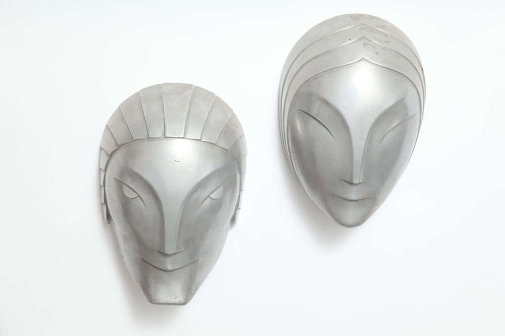 A superb pair of pewter masks once part of wall sconces from the Roxy Theatre. The set includes a male and a female mask, in highly stylized fashion. This set was featured on the cover of Antiques World, 1979, in a story about Dr. Annella Brown's