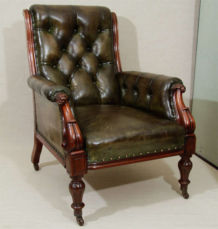 William IV Period Mahogany Gentleman's Library Chair in Dark Green Tufted Leather with Brass Nail Head Detailing and Carved Mahogany Scrolled Arms and Legs on Brass Casters. England, c. 1840<br />
<br />
29 inches wide x 34 inches deep x 37 inches