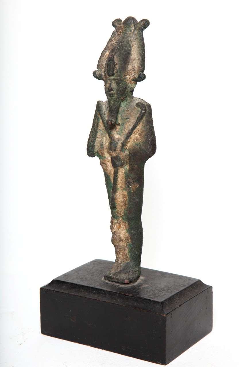 The Lord of the underworld, bearded and standing in mummiform posture with plumed headdress with ureas and holding crook and flail across chest. 

Remains of Gilding.
Excellent ancient patina.

Dutch Private Collection Acquired before 1949.