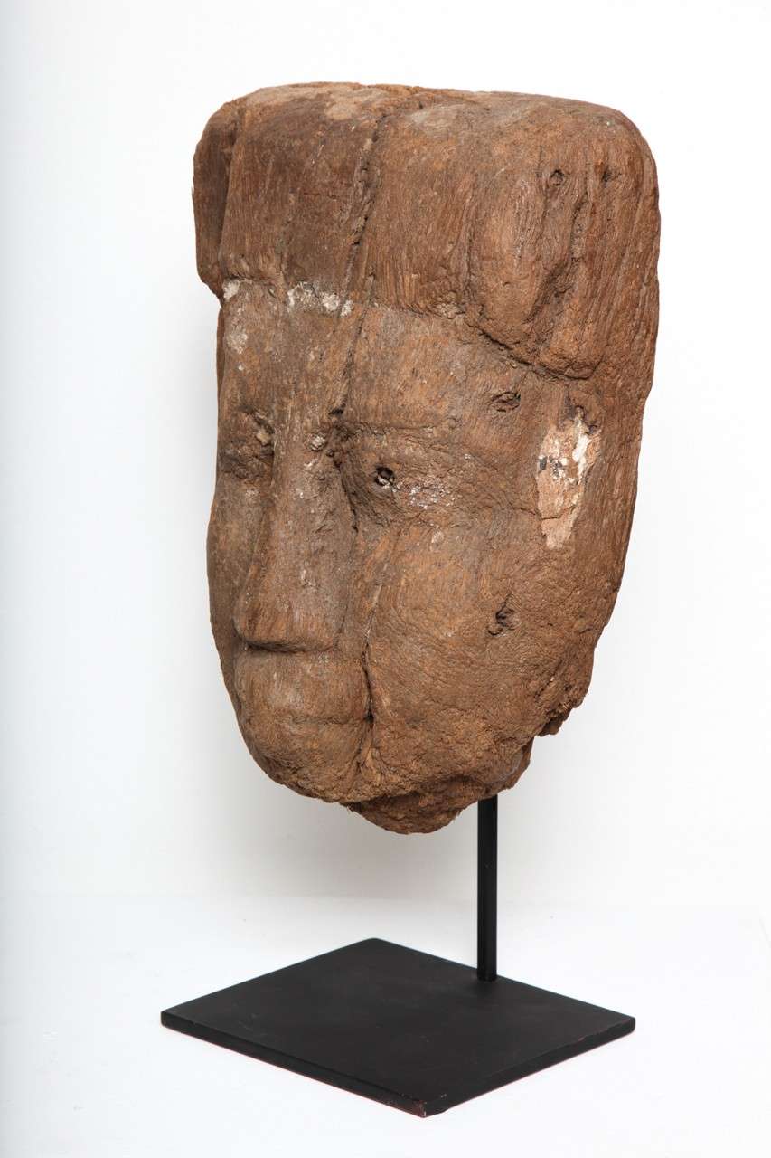 Rough exposed raw wood mask with pleasing facial features; headdress across forehead; flat back and with residual dowels remaining, minute remains of pigment on surface.

11-1/2 inches (27cm) H. + custom mount (which adds additional height (can