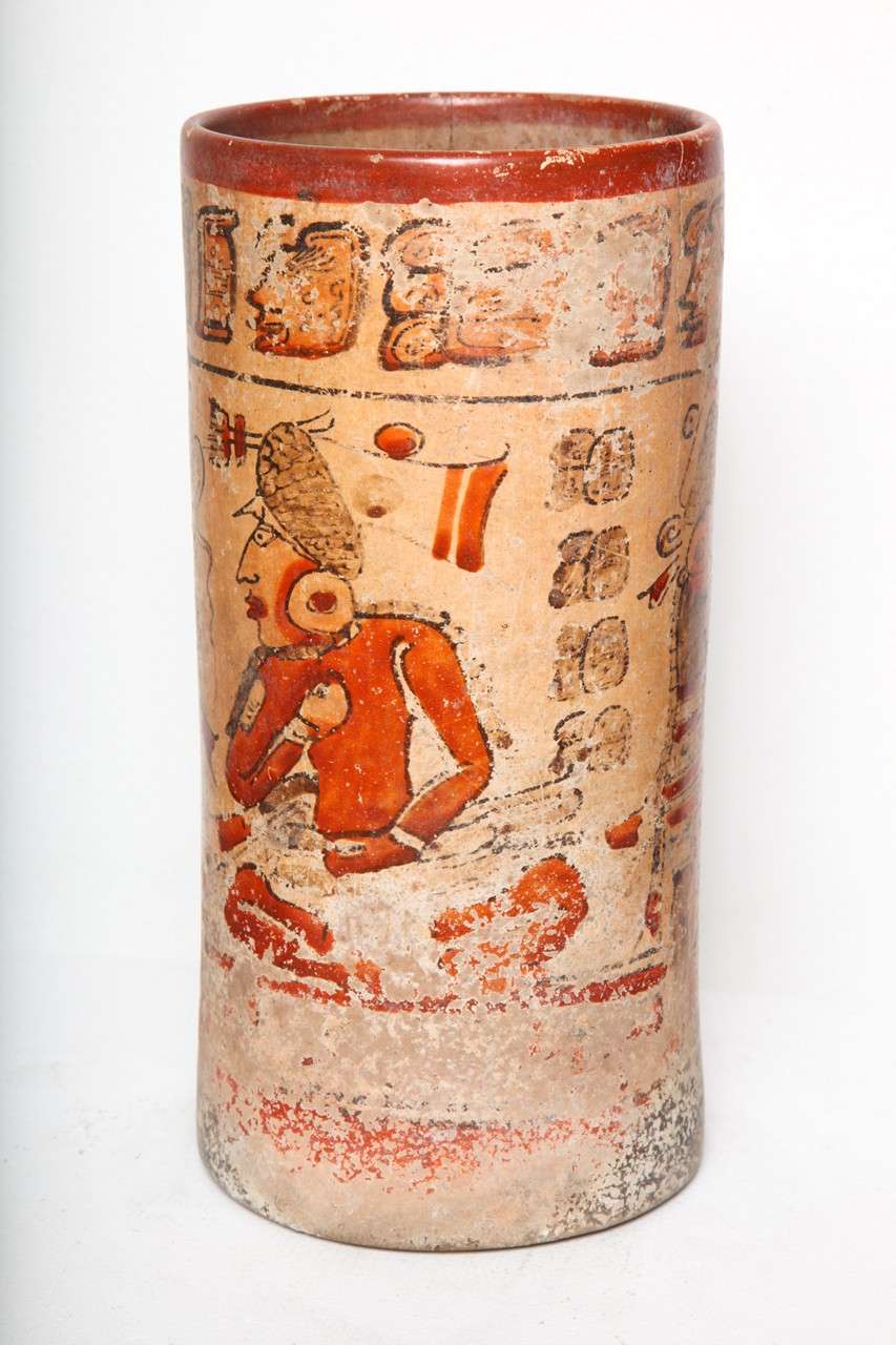 A tall polychrome ritual vessel with a similar scene on either side consisting of an enthroned Lord with a standing figure before him. Multiple hieroglyphic inscriptions in field and below rim. 

All original pigment no repaint or