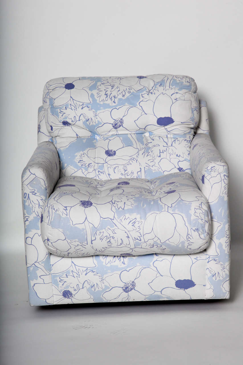 Modern cushiony swivel / rocking armchair upholstered in a blue and white floral fabric.