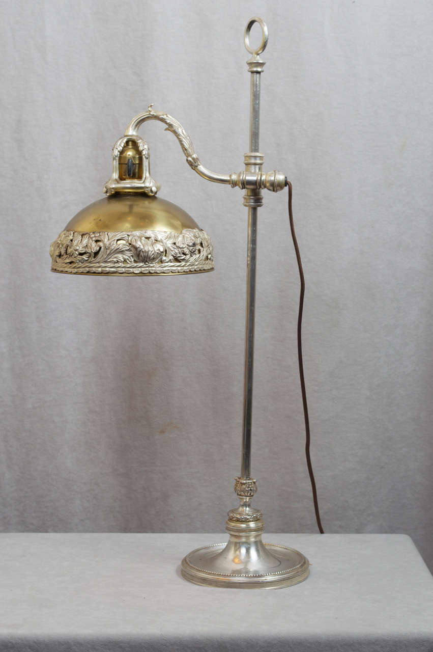 If you carefully study the pictures of this lamp, you will see the highest quality workmanship that can be offered in bronze work. The lamp is mostly silvered except for the partial gold on the upper portion of the shade. The arm goes up and down