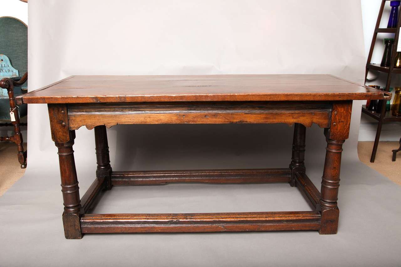 Fine mid-17th century English oak refectory table, the well patinated three plank top with breadboard ends over stretcher base having channel molded and shaped aprons joining balustrade turned legs, joined by molded box stretcher, the whole with