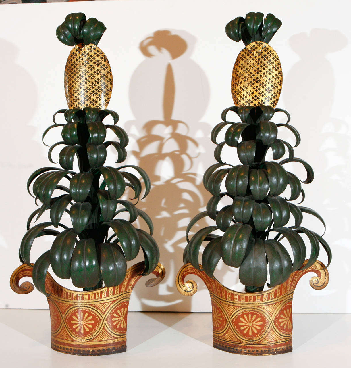Large, hand-painted, tole, parcel gilt, pineapple tree wall sculptures.