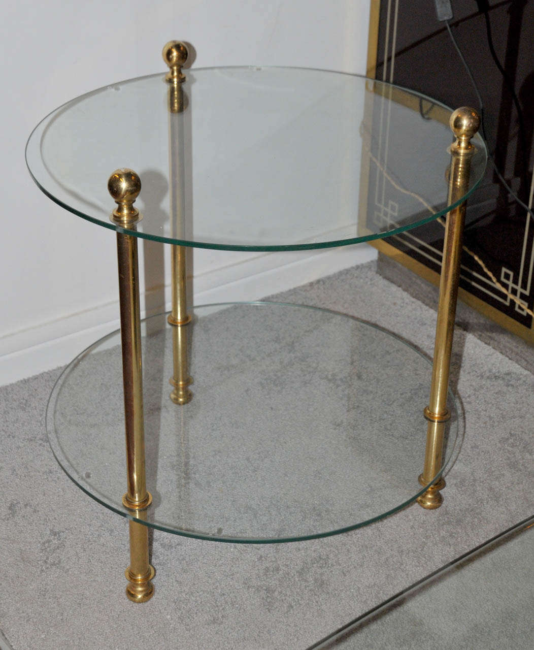 1960's pair of gueridons. Gilded brass legs and glass tops. Legs top sphere ends in bronze. Very good condition. Normal wear consistent with age and use.