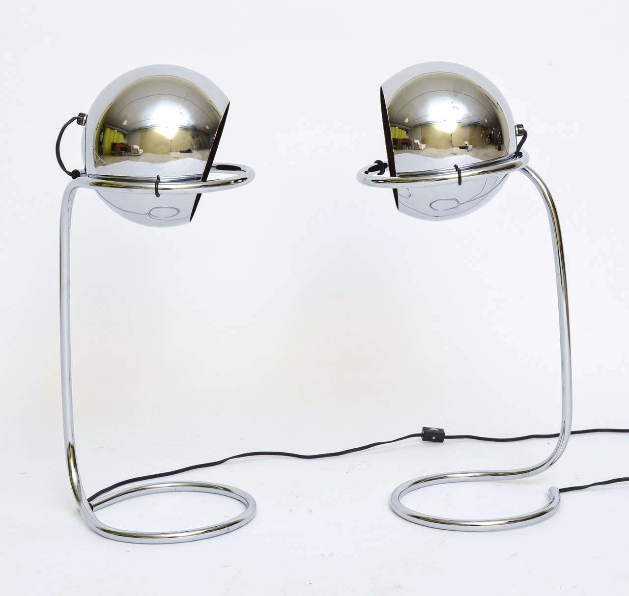 Rising on curling tubular chrome stands, this pair of chrome ball lights are very Panton inspired. with movable heads the lamps can beam upward, down or to the sides, your move. Each takes a single medium base bulb, 75 watts max.
Price is for the