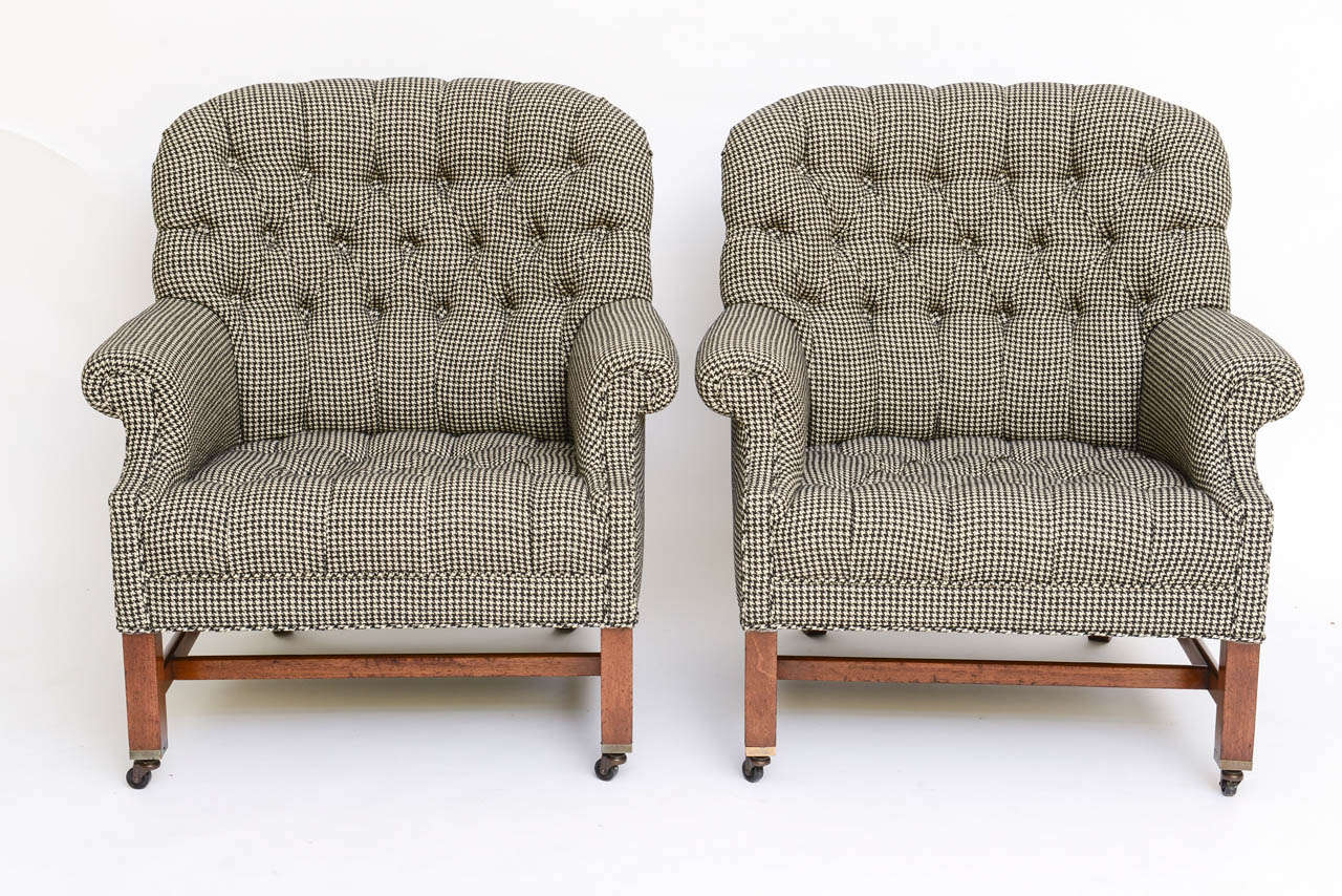 ...SOLD...Regal, masculine and Edwardian style powerful room anchor club chairs in deep button tufted houndstooth.  With rolled arms and front leg brass casters, they feature walnut legs and stretchers with an open back leg design, quite striking. 