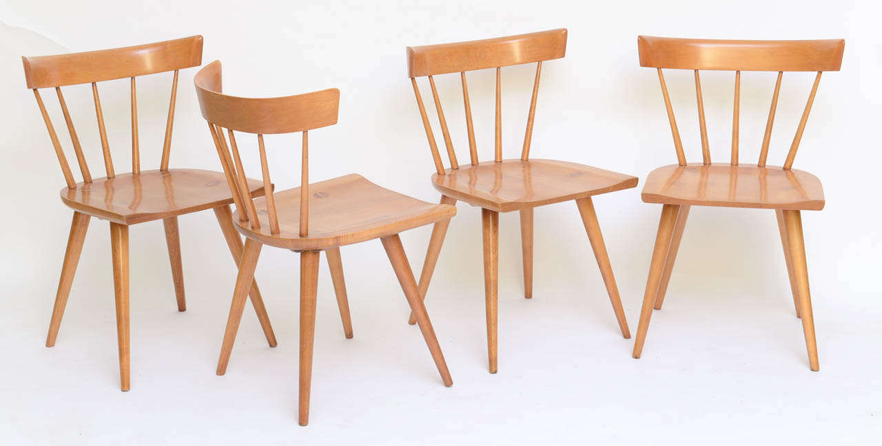 Iconic set of four Windsor style chairs by Paul McCobb for Winchedon, part of the Planner Group line. In solid maple, they have a stylised spindle back, tapering legs and an early ergonomic formed seat with the leg tops forming a large slotted screw