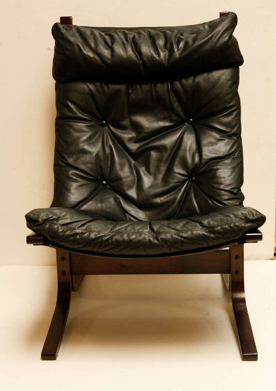 Pair of Ingmar Relling for Westnofa black leather Siesta chairs.  Molded wood frame made of a cherry wood.