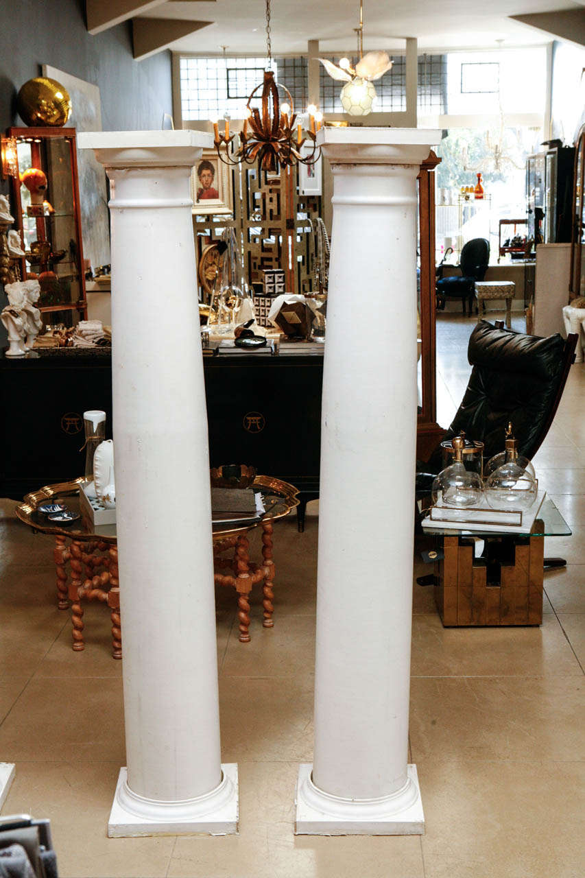 Set of six white doric columns made of coated fiberglass with a square removable base.