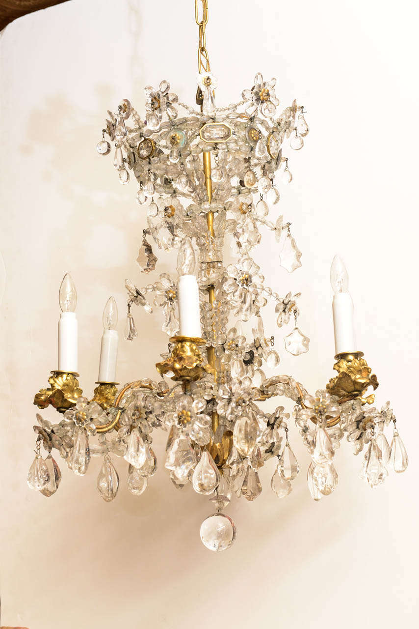 A very special and rare chandelier, its corona in the form of a Royal crown, including unusual bronze-wrapped baguette crystals; suspending an elaborate trellis of spherical and flower-form drops of both rock crystals and amethyst crystals, hung à