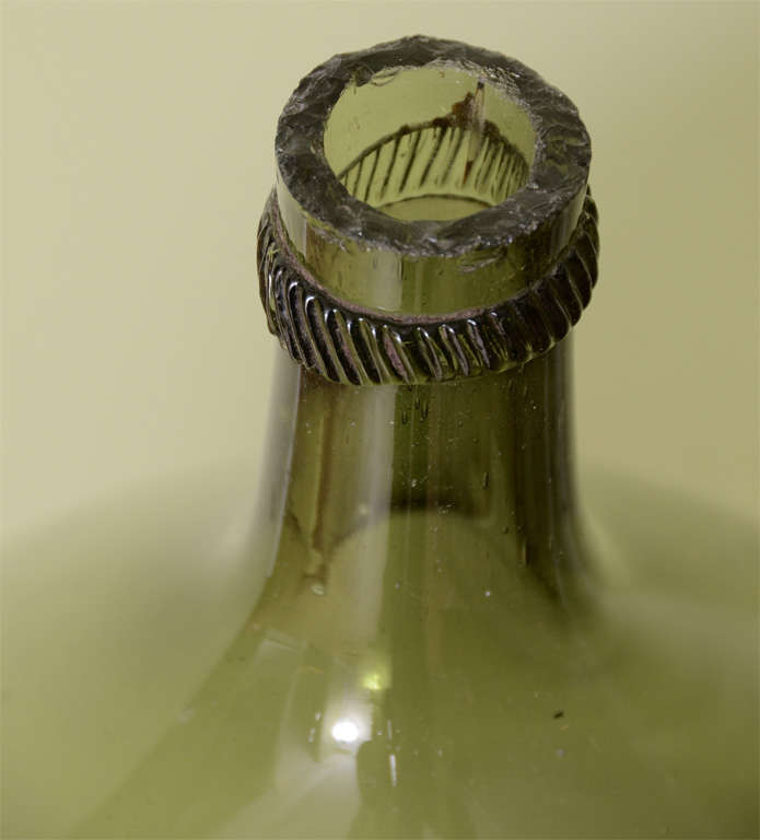 This is a large bottle usually glass, sometimes sandstone, protected by foam, straw or wicker woven into the very walls and used for storage and transport of food, beverage and other liquids (alcohols, acids, etc..). Spherical, flattened at the