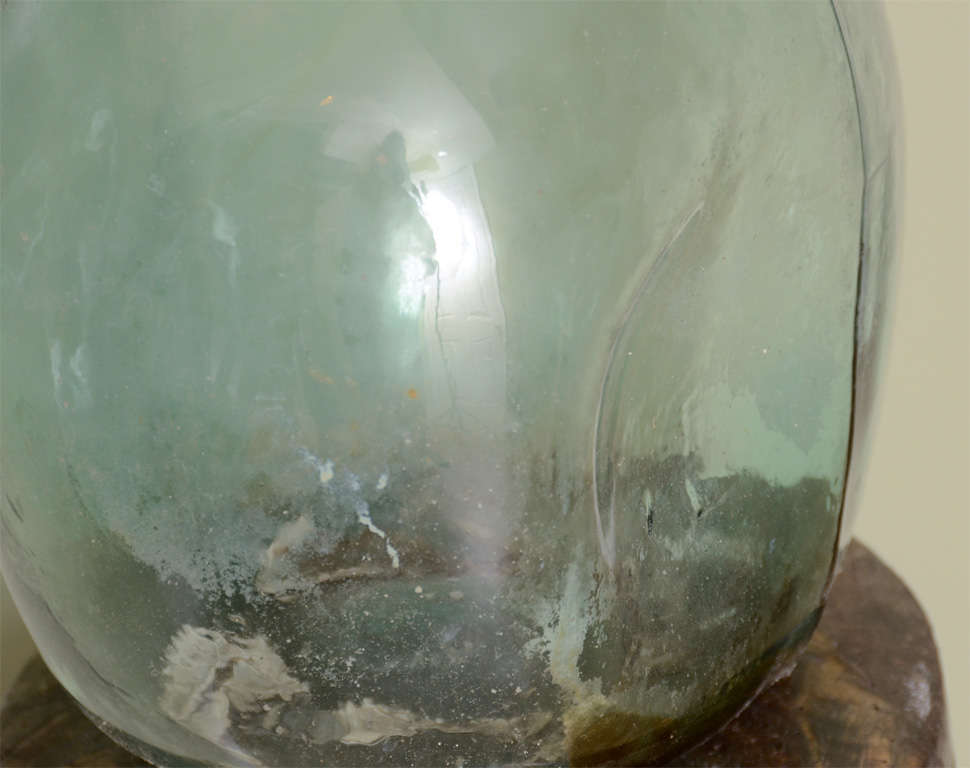 This is a large bottle usually glass, sometimes sandstone, protected by foam, straw or wicker woven into the very walls and used for storage and transport of food, beverage and other liquids (alcohols, acids, etc..). Spherical, flattened at the