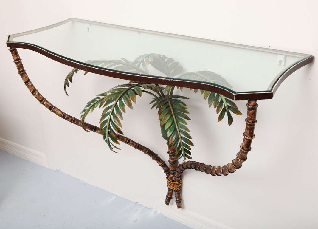 Lovely faux bamboo tole console with glass top covering sprouting palm fronds.