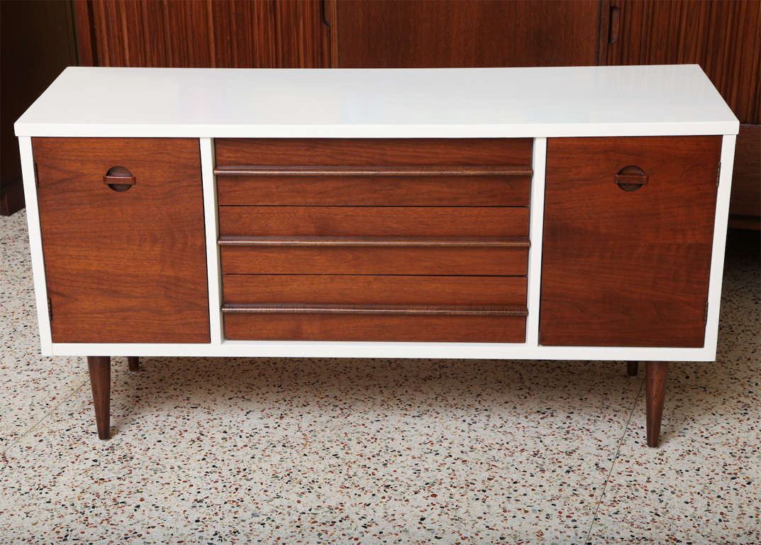 Smart lines and a smaller scale highlights this beautiful credenza sideboard in a rich warm walnut with a white chocolate lacquered cabinet body.  Mid-century with Danish inspiration, it has wonderful inset door pulls on the doors opening to a half