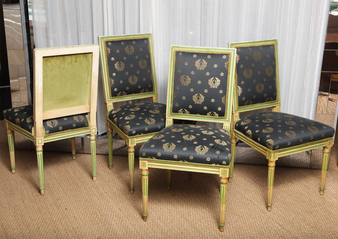 Set of four French dining chairs in the style of Louis XVI, circa 1940s, distress-painted, padded back and seat upholstered in original blue silk Empire fabric with original velvet to back. Raised on squared tapering legs By Jansen.