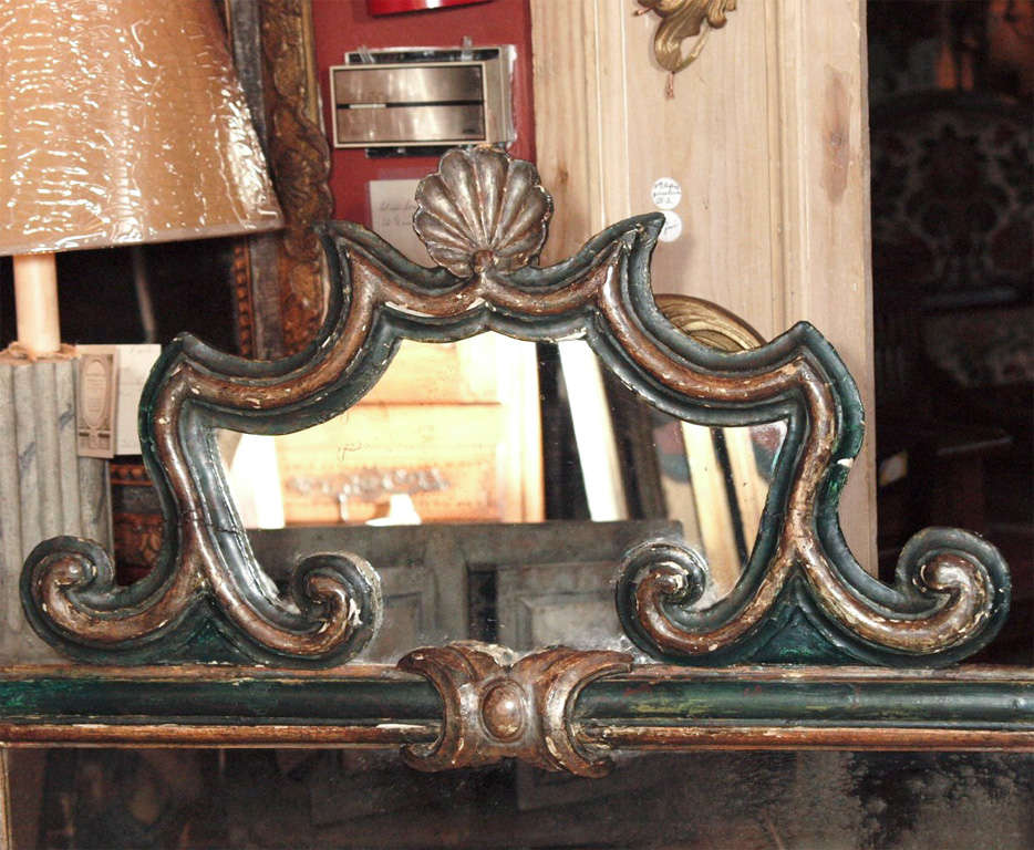 A painted Florentine style mirror.  The larger mirror is crowned with a smaller framed mirror in the shape of a cartouche.