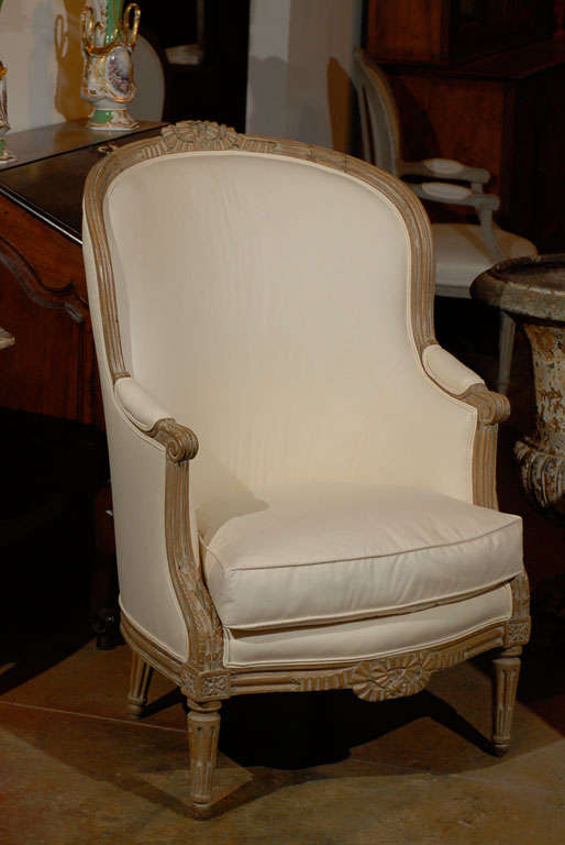 A French Louis XVI style beechwood barrelback bergère chair with carved motifs from the 19th century and new custom upholstery. Born in the 19th century, this French bergère adopts the Neoclassical lines of the Louis XVI period. The beautifully