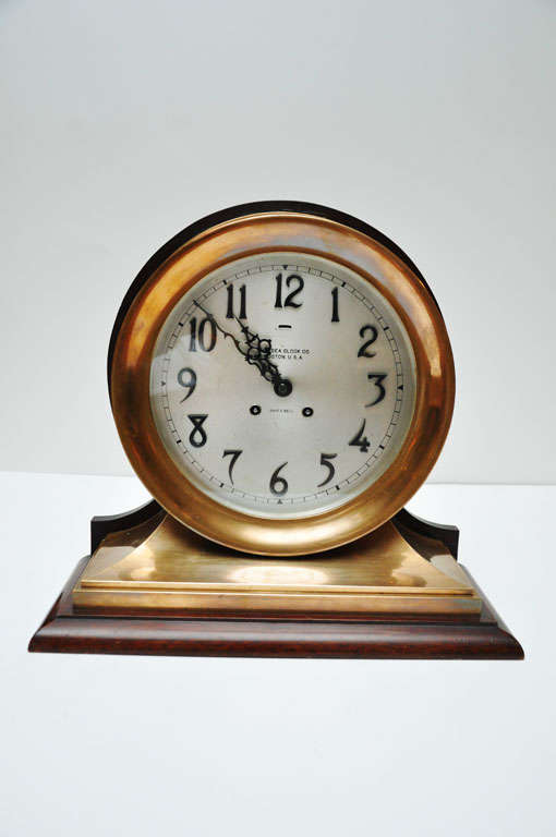 Fine brass Chelsea ship's bell clock, mounted on wood stand. Circa 1910