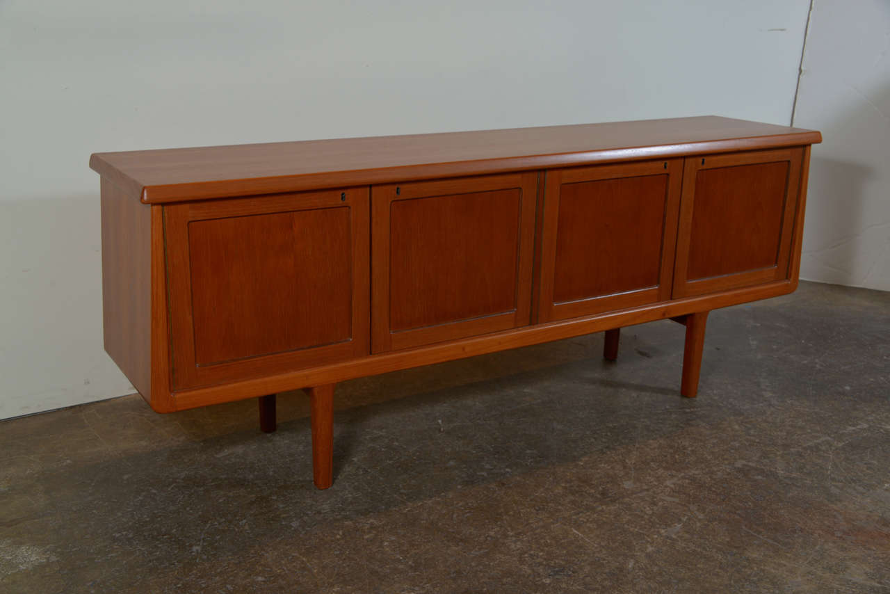 Sideboard designed by Arnt Sørheim, and produced at Brødrene Sørheim - Norway in 1960. This sideboard has four door panels that open to open storage and a set of five pull out drawers. Veneer and massive Teak