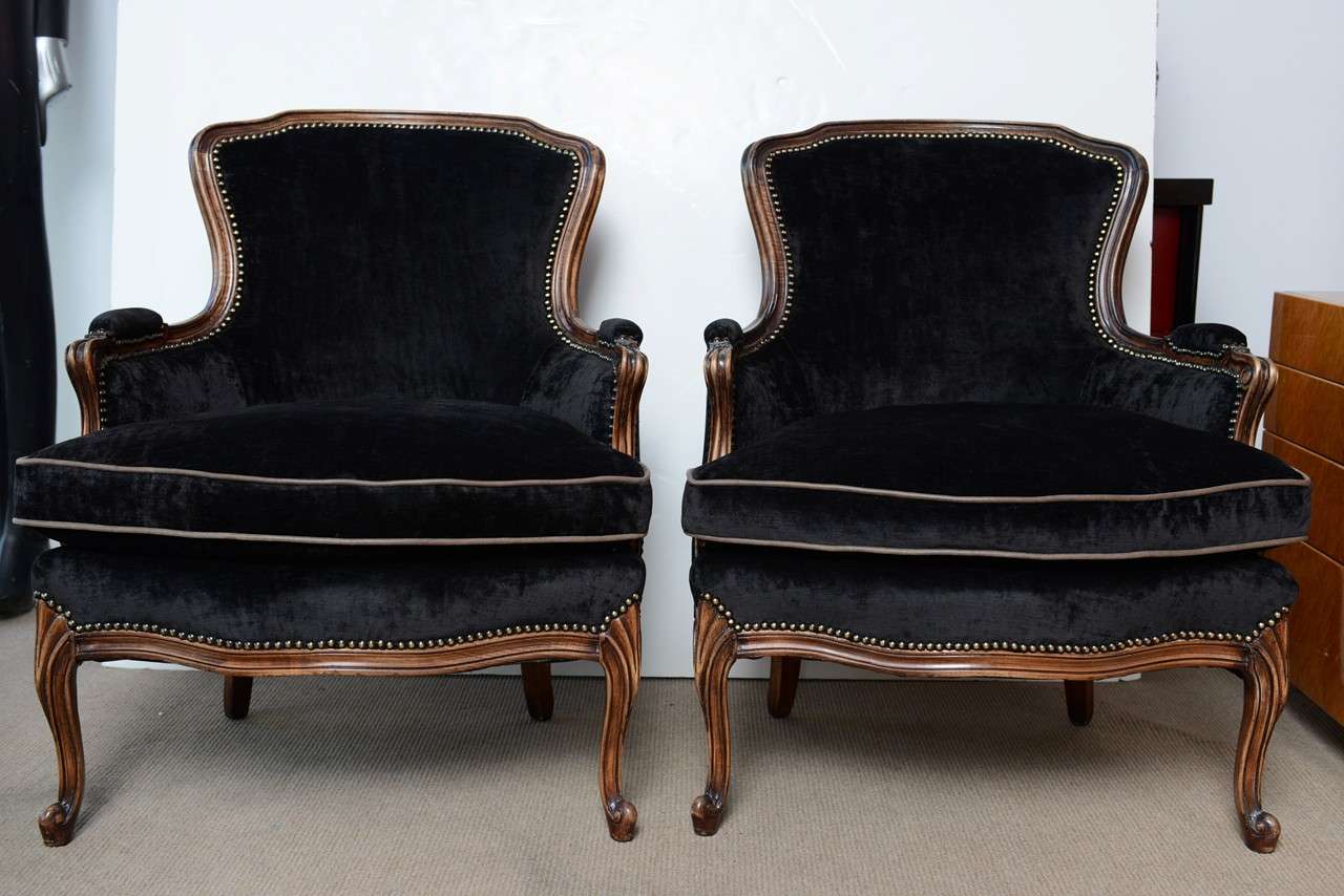 Exquisitly French Vintage Pair of Louis XV Bergere Chairs hand carved details on front with cabriol leg. Recently reupholstered in a low pile black velvet, round upholstery tacks lend a regal edge. Down-filled seat cushions (extremely  confortable)
