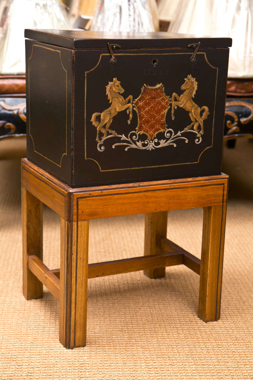 A 19th century wooden ammunition chest with hand-painted detail on a custom-made stand. Perfect as a side table.