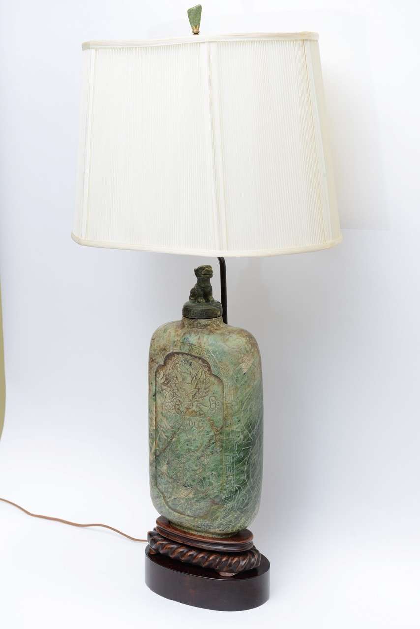 Wonderful scale and presence, an Asian aura and regal stature highlight this table lamp from the 1940s. Large-scale, this beautifully carved snuff bottle shaped jade colored soapstone vessel is itself over 17 inches high and sits mounted on a