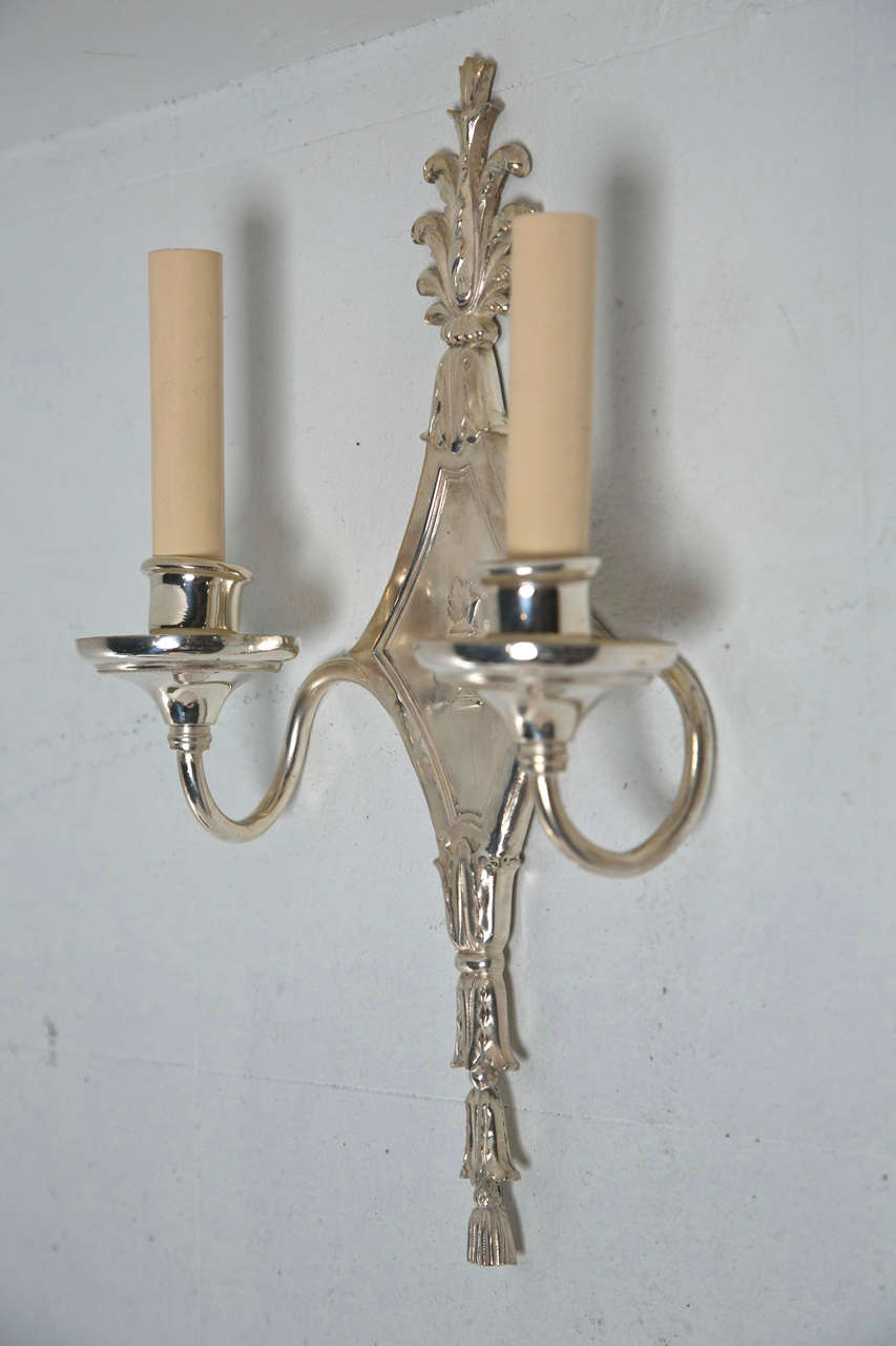 Pair of Circa 1920's Caldwell silverplated sconces, Neoclassical style with scrolled arms. 8 pair available.