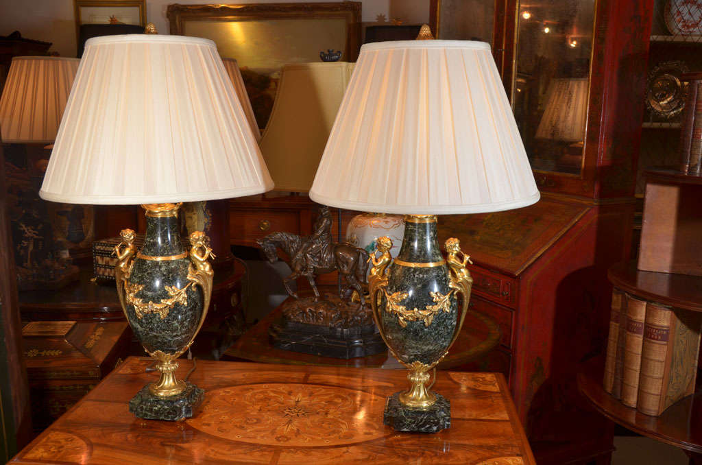 pr of green marble and dore bronze urns made into lamps with bronze dore cherubs playing flutes