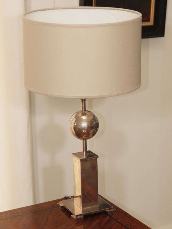Table lamp in silverplate with square column on raised plinth supporting a rod with two spheres; original taupe lined linen shade