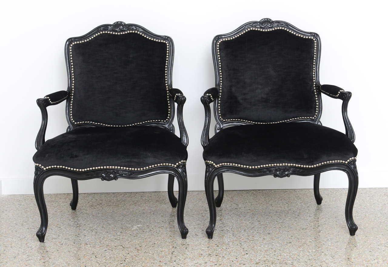 Pair of black crushed velvet Hollywood Regency bergeres with silver studs and black lacquered wood frames.

Please feel free to contact us directly for a shipping quote or any additional information by clicking 
