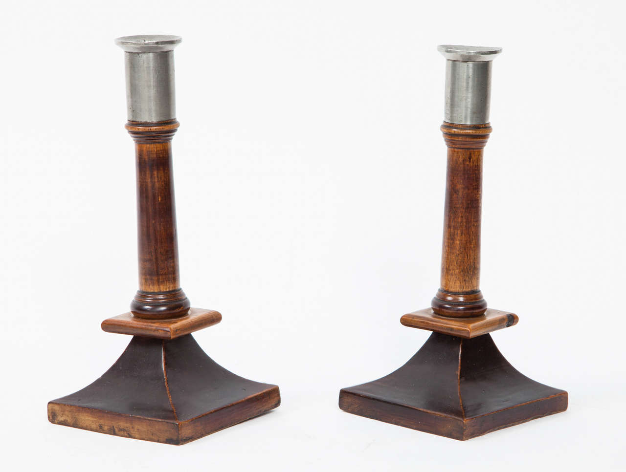 A pair of Swedish birch, stained birch and pewter candlesticks, Late 19th Century, of classic form with tapered square base and pewter candle holders.