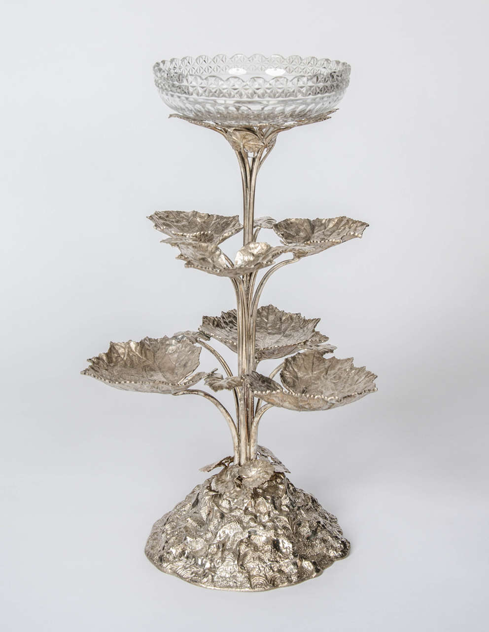 A silver plated Victorian centrepiece formed of three layers of leaves with stylised rock base and a Victorian cut crystal epergne bowl.