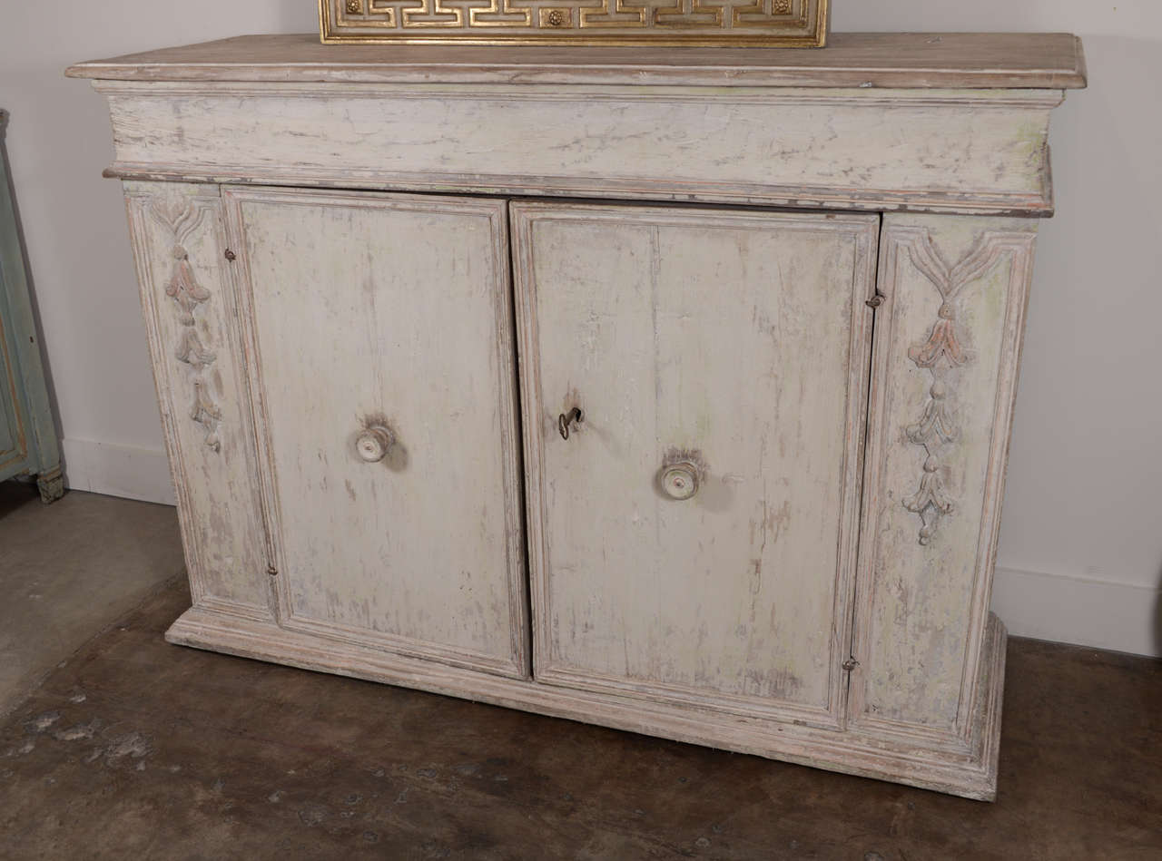 18th century Italian buffet from a Palazzo in Venice. Beautiful intricate carving on panels down the facade of piece and along the perimeters panels. Well weathered original paint. Handsome piece.