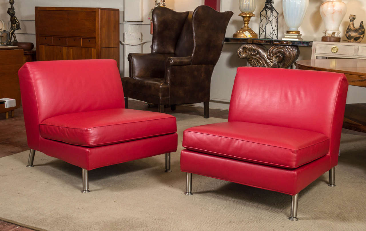 Great looking pair of lounge chairs from Italy, by Minotti. Both covered in a beautiful supple red leather, all sitting clean design cylinder steel legs.