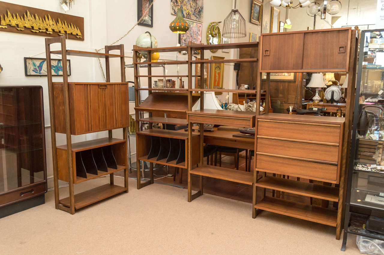 A very large five bay total shelving system, shown as a four bay here, shown three connected and one free. Walnut veneer and solid, stamped on the underside of a cabinet Yugoslavia, unit was made 1950s. Two cabinets, one chest of drawers, one