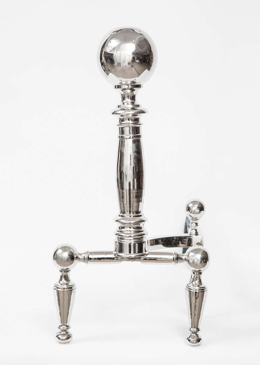 Fantastic pair of stylish andirons with a cannonball top and tapering legs in a polished nickel finish.