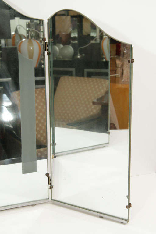 Glamorous Art Deco triptych mirror with arched top and silvered wood trim. Center mirror features two back-lit frosted glass bands at either side.