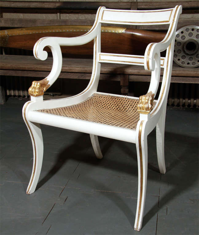 The chairs with scrolled backs and scrolled arms on parcel-gilt lion paw supports with cane seats.