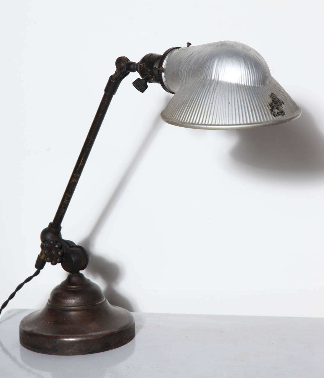 Early 20th Century Industrial O. C. White Brass, Iron and Glass Articulating Reading Lamp, Desk Lamp, Bedside Lamp. Featuring an adjustable rotating Brass arm on heavy round base with rich dark Bronze patina throughout.  With new old stock,