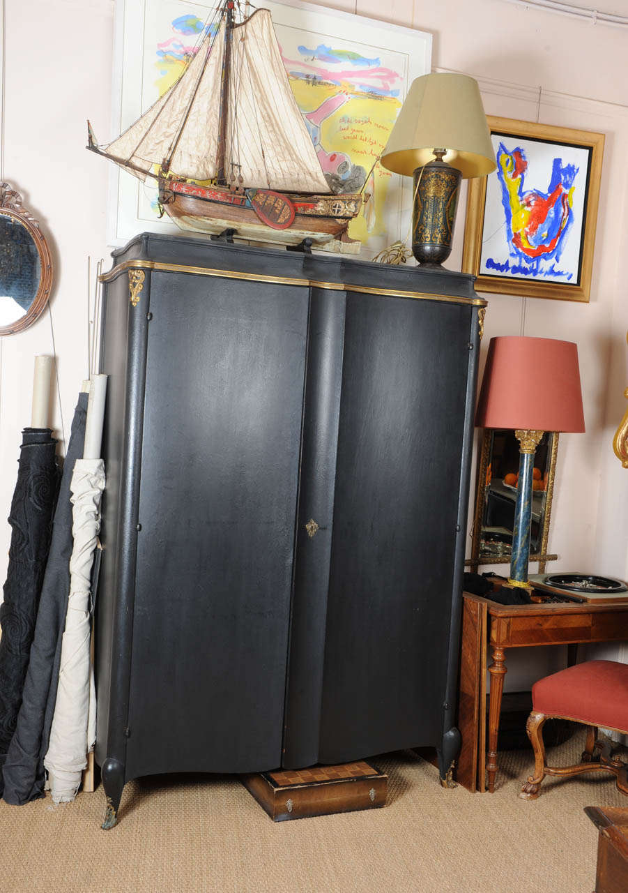 French mahogany, black patinated wardrobe, with goldened metal decorations.
The doors are nicely curved.