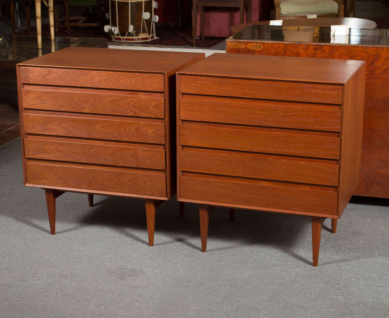 Offering a rare pair of teak Danish Modern bachelor chests designed by Henry Rosengren Hansen for Brande Mobelindustri .  The chests feature very nicely finished backs, discretely concealed drawer pulls, and five drawers each. The chests are branded