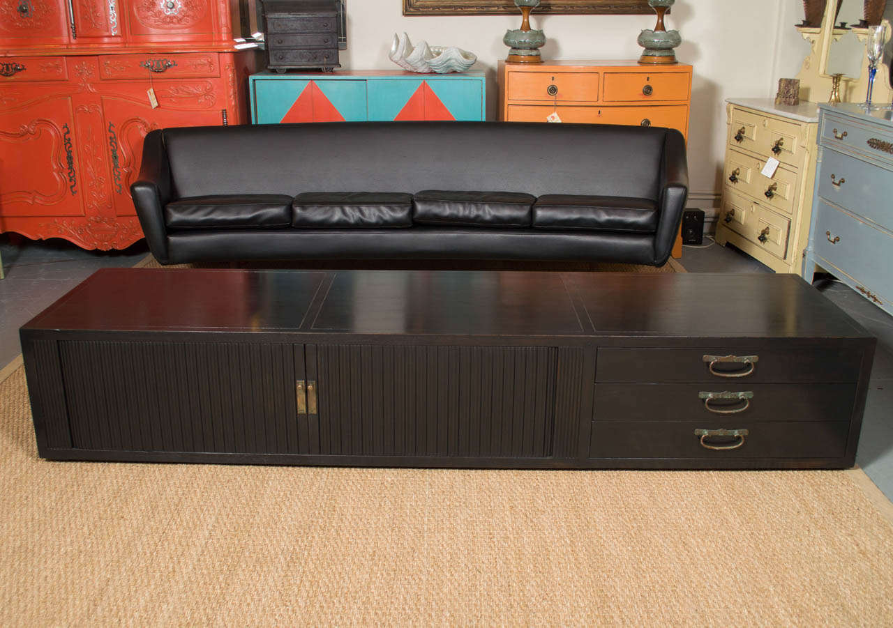 Circa 1960's long and low black console table. With tambour doors one end, and three drawers at the other, with a nice finished back. It's perfect for todays TV's. Made by Baker and attributed to the designer Michael Taylor.